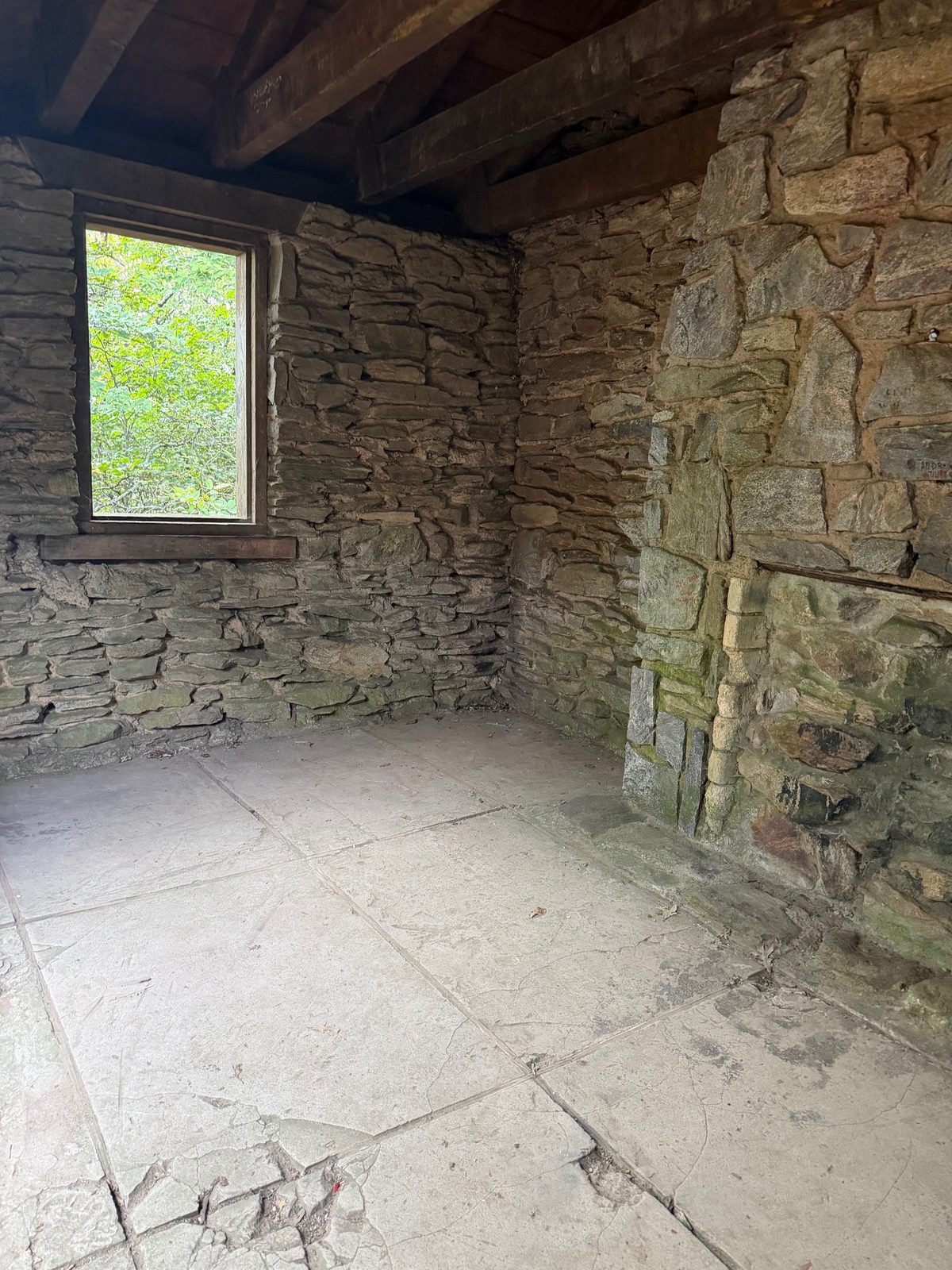 Inside the stone shelter, with a window looking out to green trees