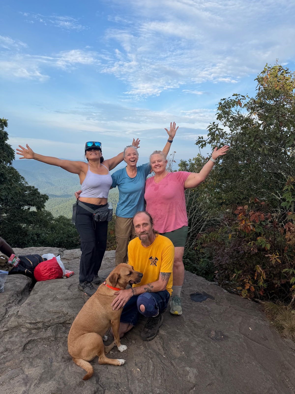 The whole group, arms raised, at the Blood Mountain summit with Sunshine the dog
