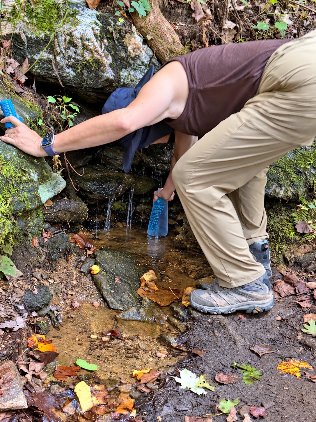 Gathering water from a small stream running over rocks